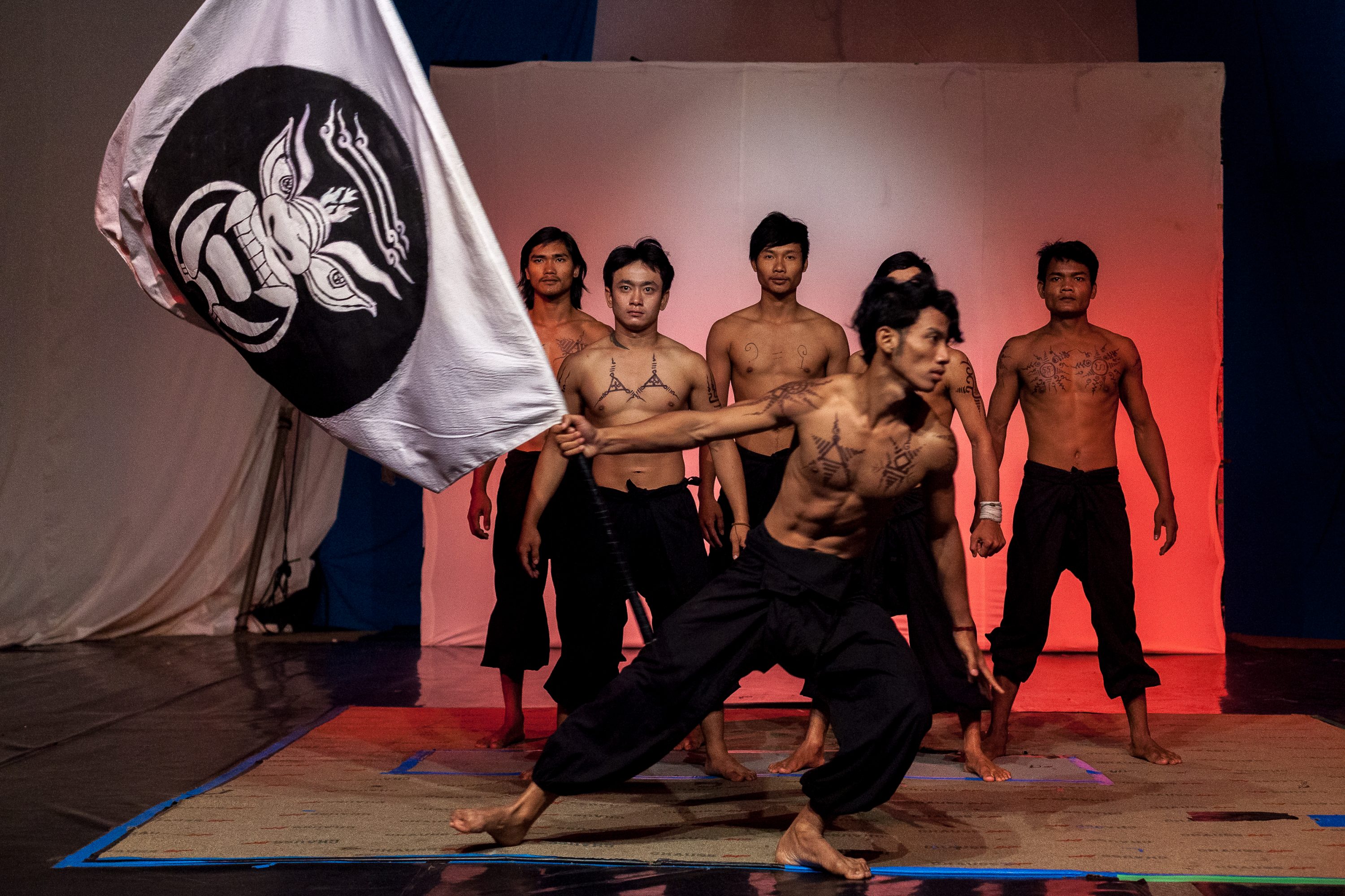 A group of artists performs scenes with flags in Cambodia