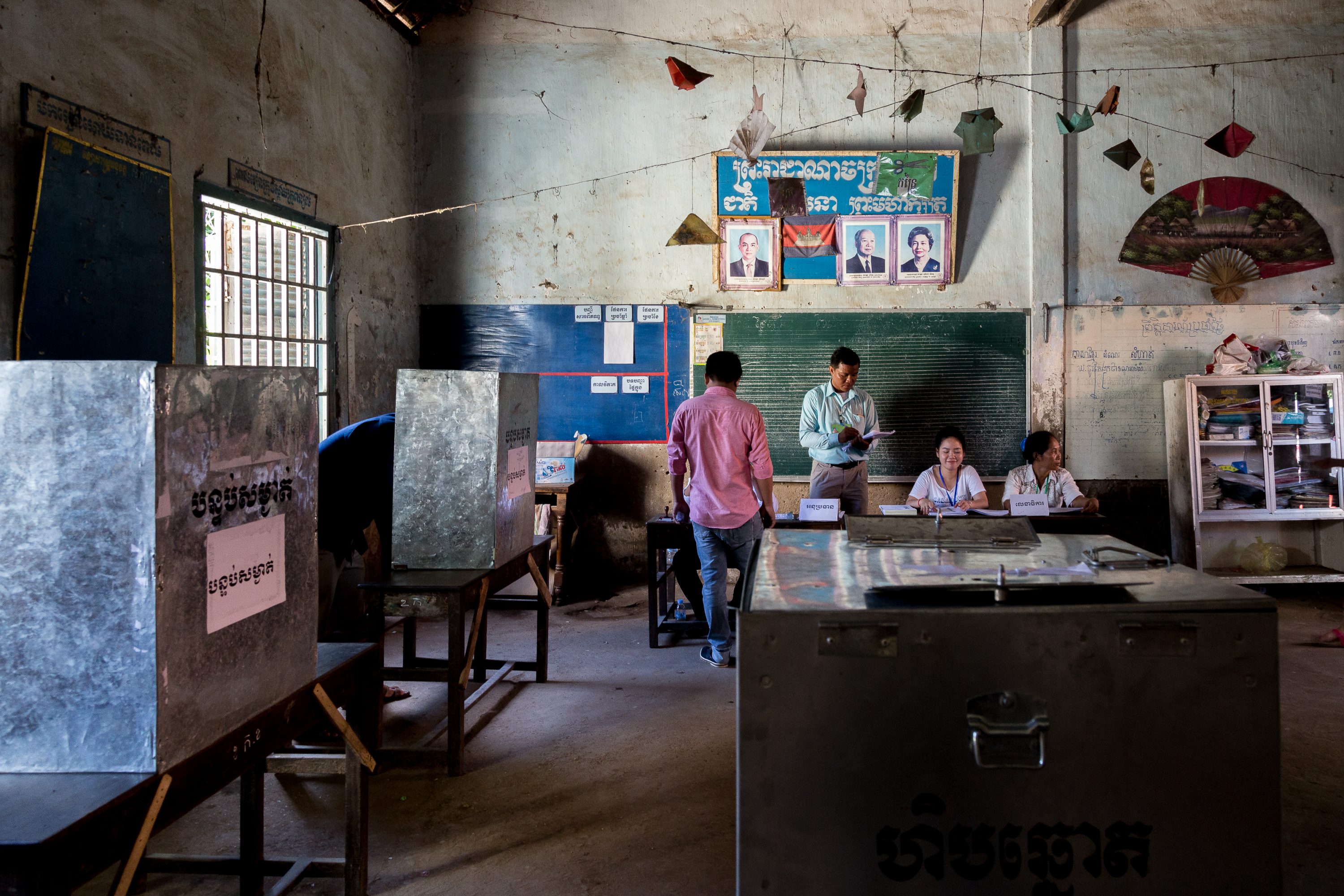 oll officials check the identity of voters before casting their ballots in Cambodia