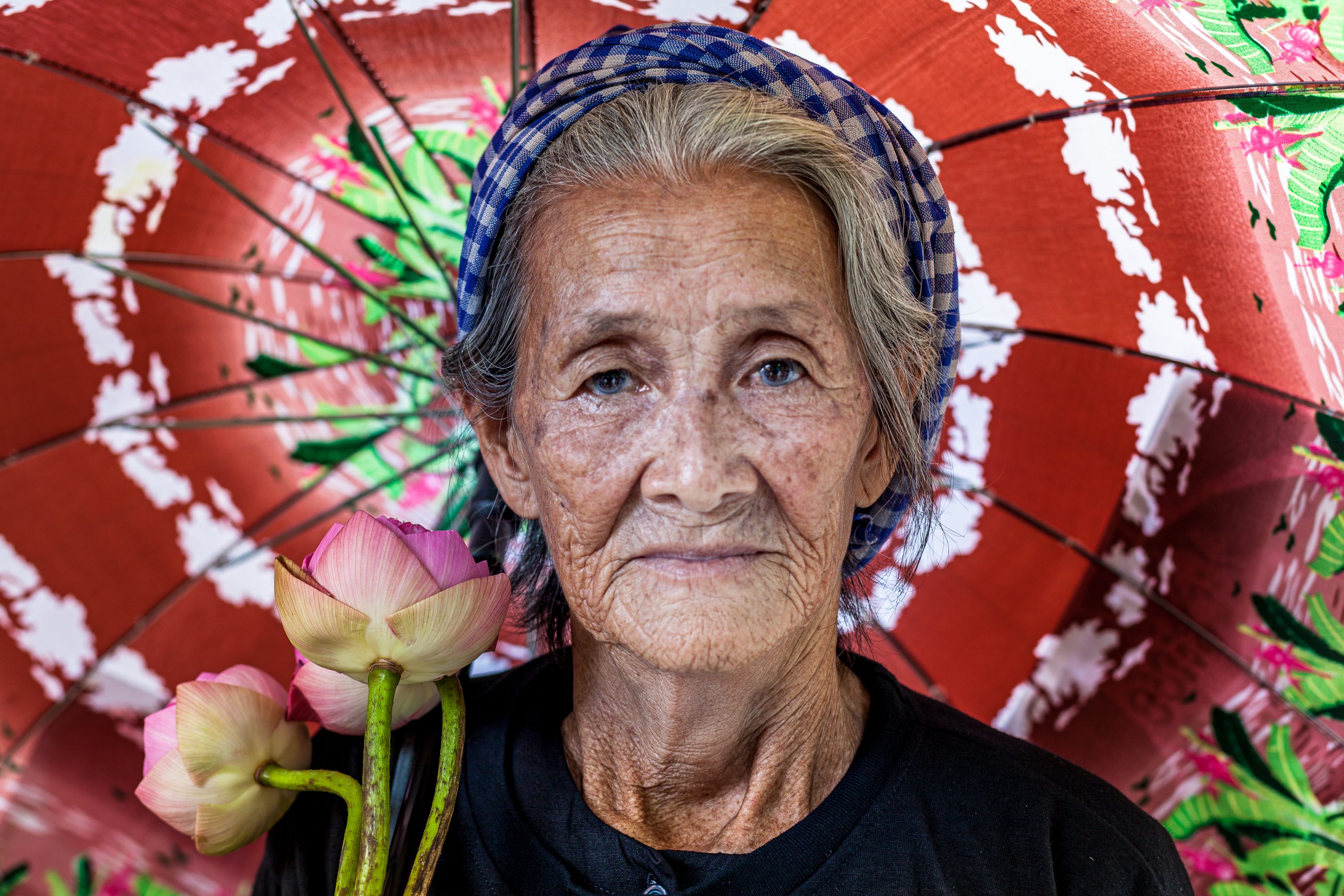 Boeung Kak Lake activist Nget Khun stands holding an umbrella in Cambodia