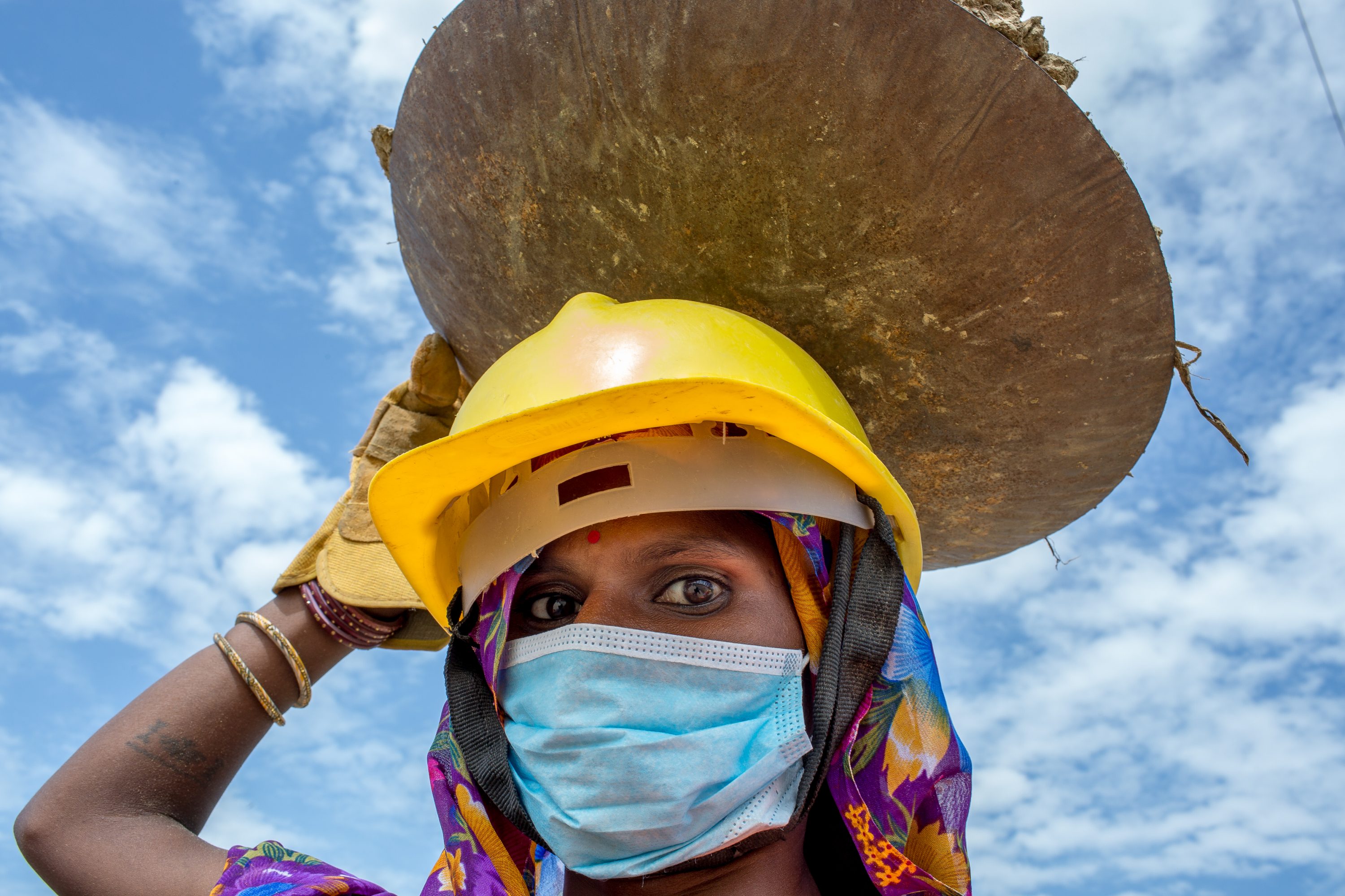 A Maithil woman stands holding a pot filed with sand in Nepal