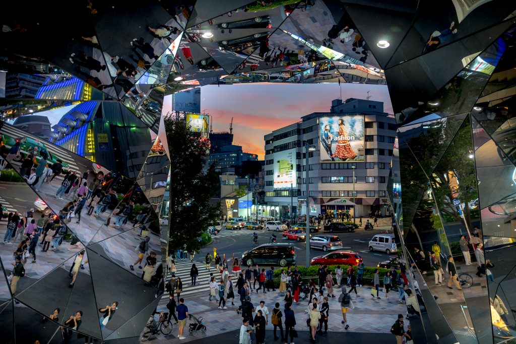 Nightlife is reflected on the mirrors at the entrance to Tokyu Plaza Omotesando in Japan