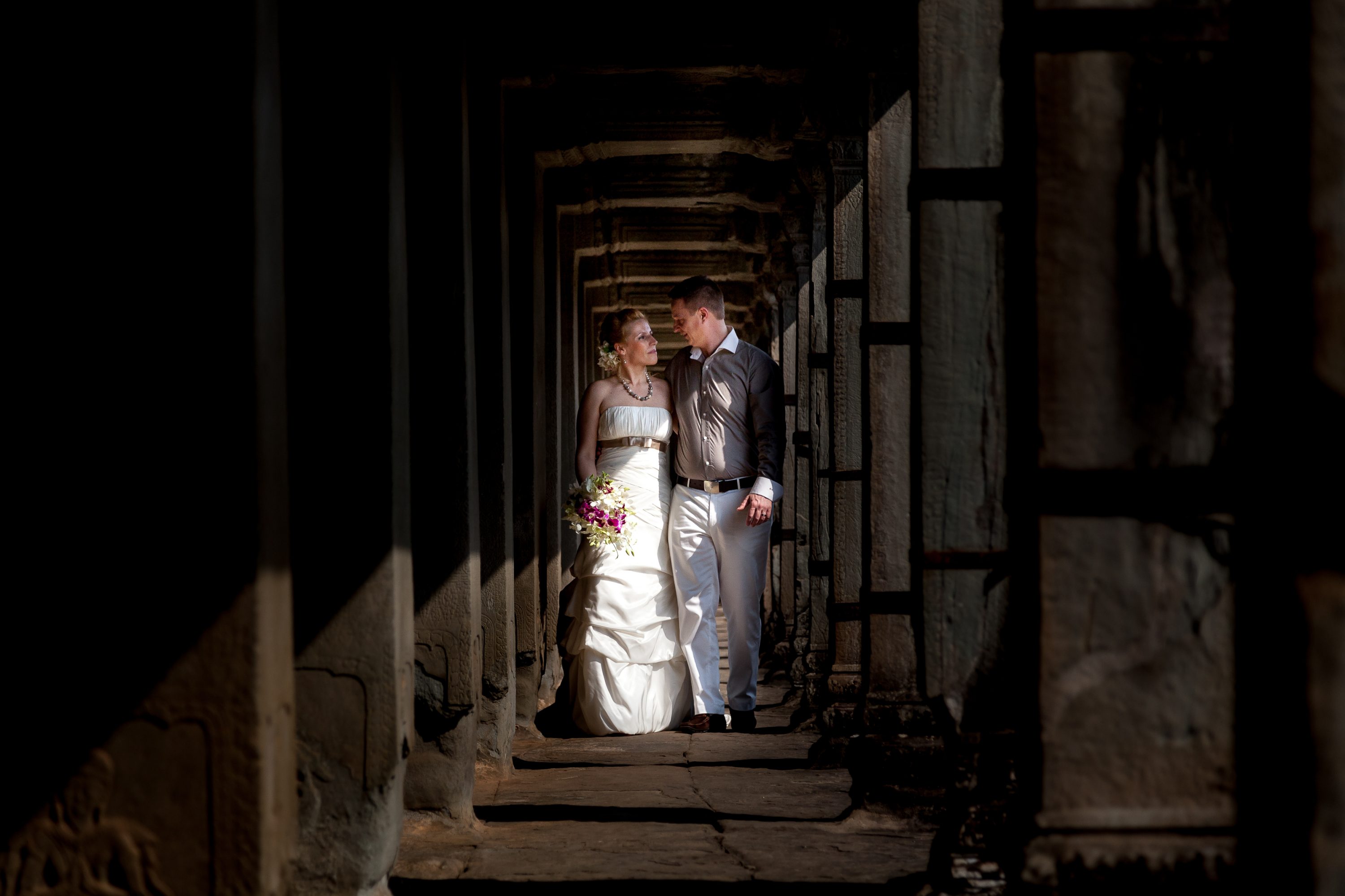 A couple walk as they pose for a wedding photo at the Angkor Wat in Cambodia