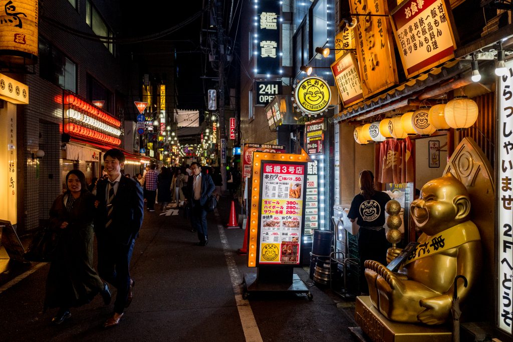 Residents stroll at night through Shimbashi in Tokyo
