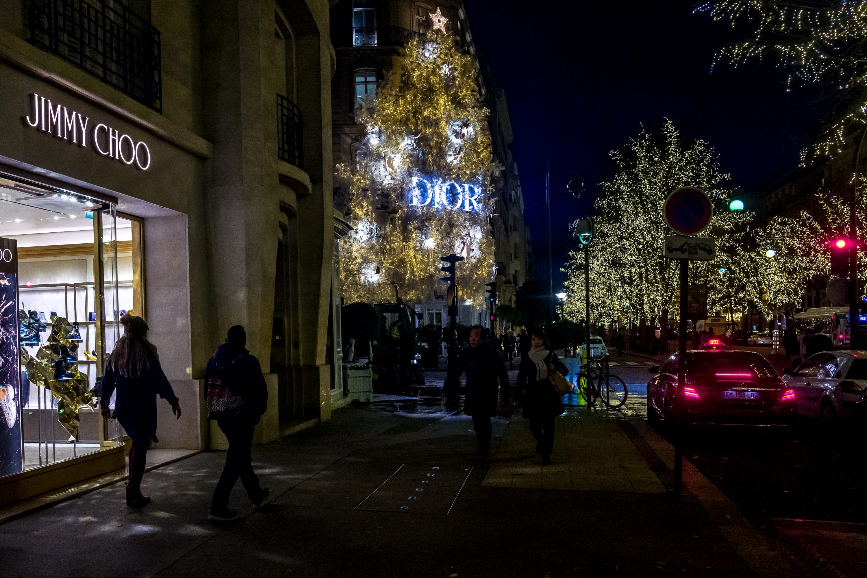 People walks in front of exclusive retailers shops located near the Champs Elysées in Paris
