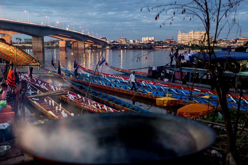 A man walks on a racing boat in Cambodia