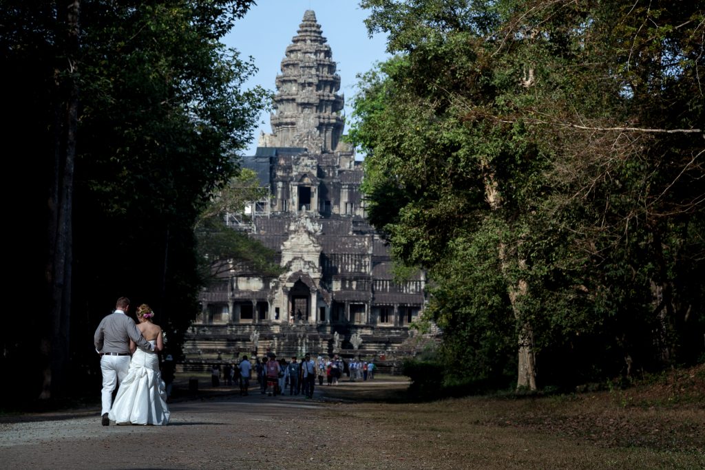 couple walk for a wedding photo in Cambodia