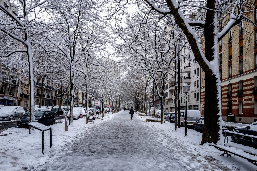 A woman walks on a snow-covered promenade in the centre of Paris