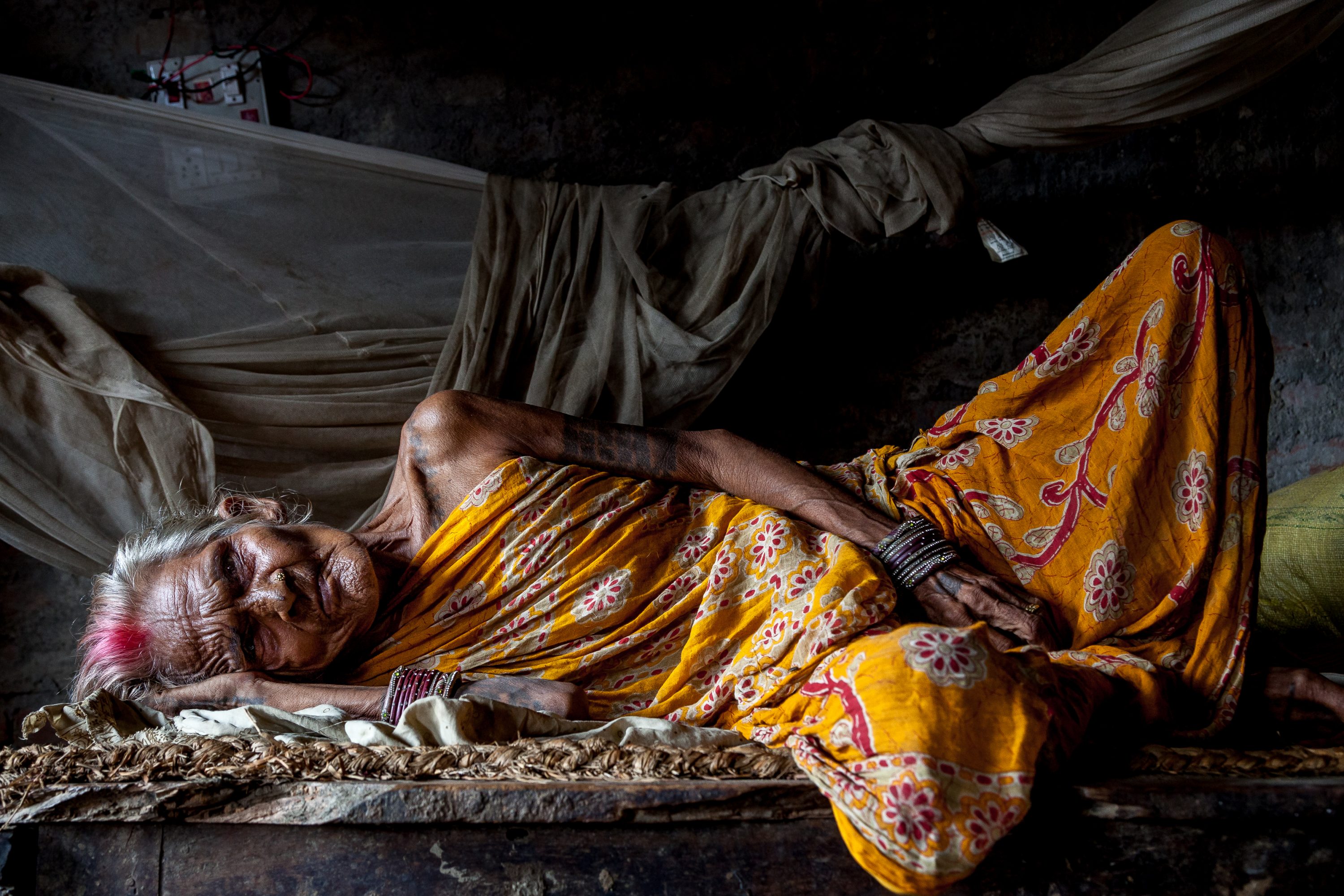 An elderly Maithil woman lays sick in Nepal