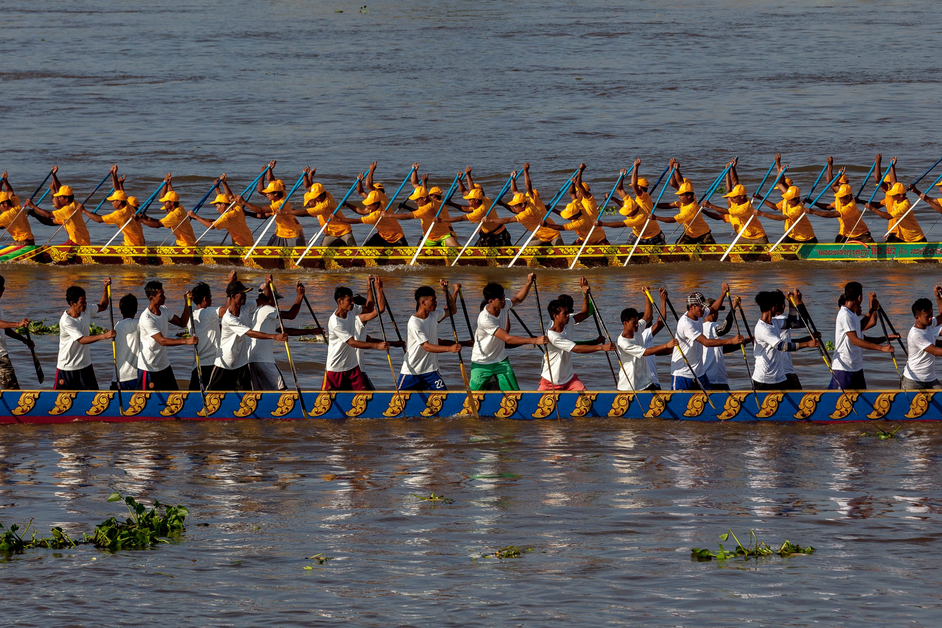 Boat crew members train on the waters of the Tonle Sap River in Cambodia