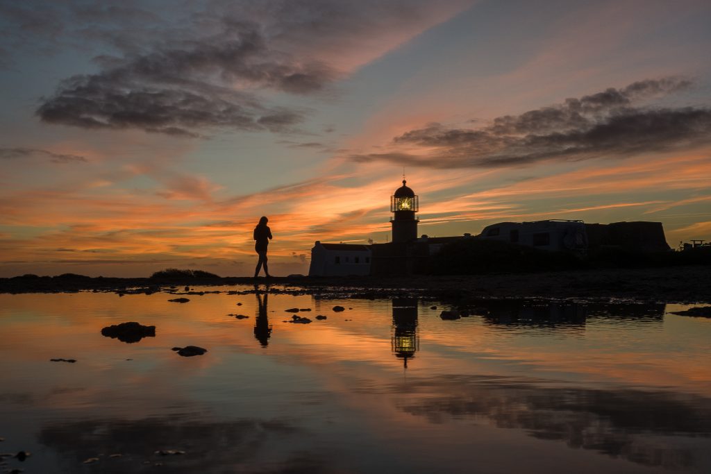 A tourist walks in front of the lighthouse in Portugal