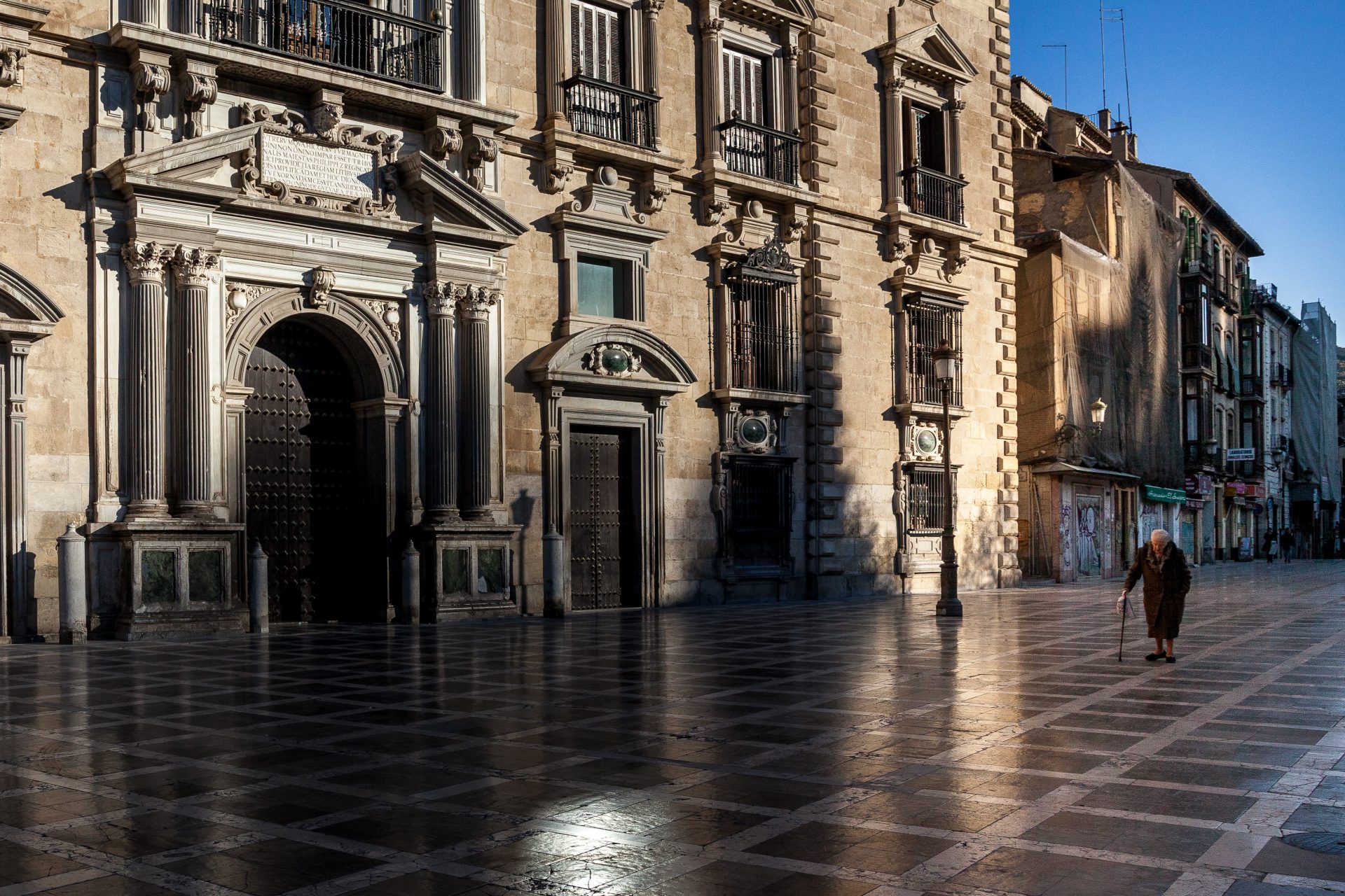 An elderly woman walks in Granada