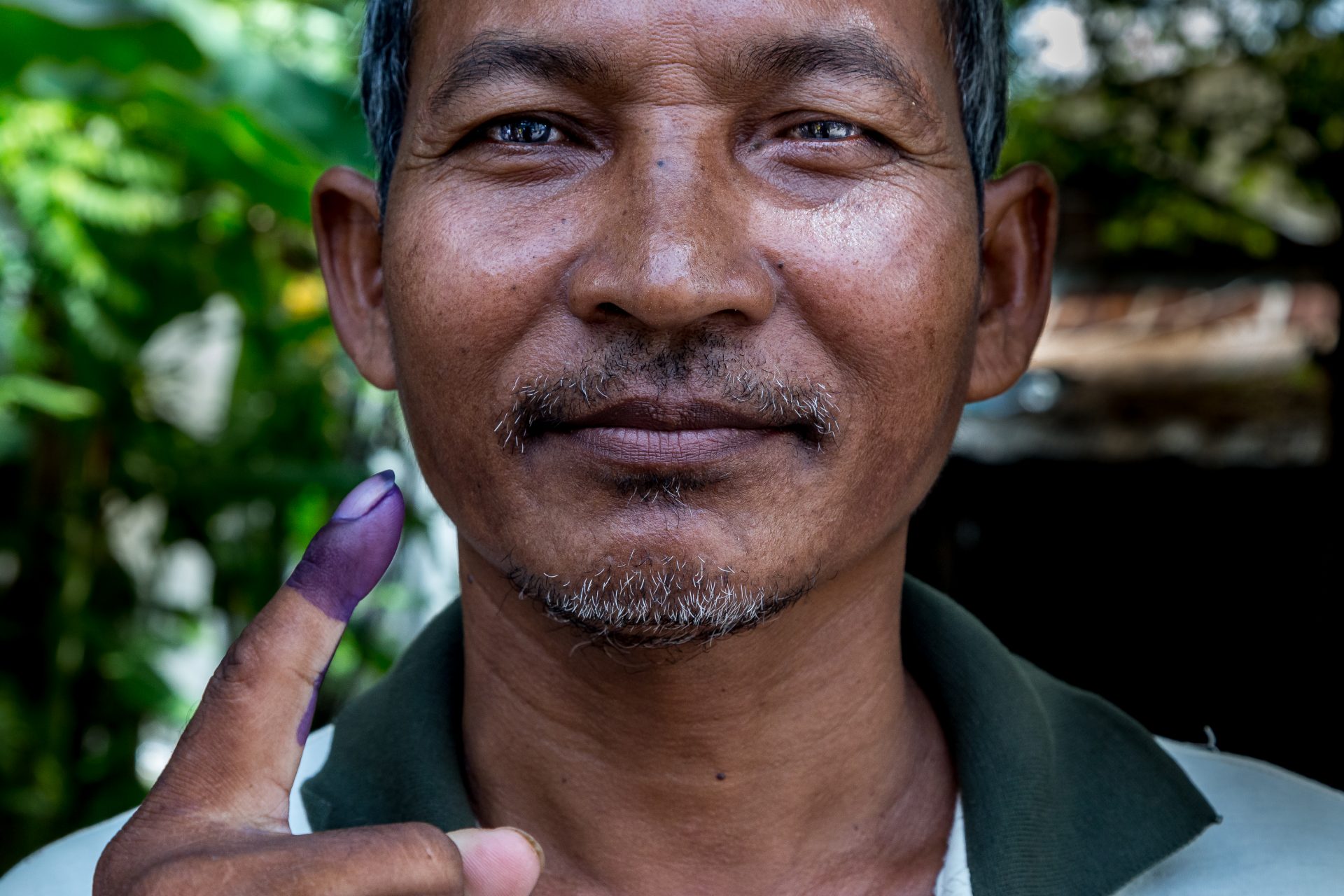 A Cambodian voter shows his inked finger after casting his vote during commune council elections