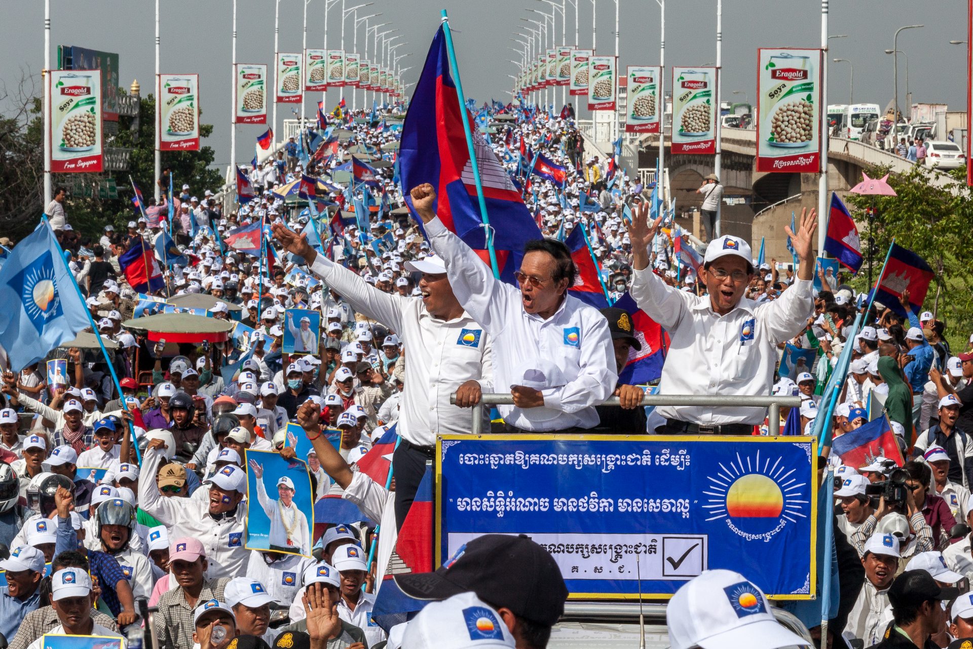 Kem Sokha (center), the president of the opposition Cambodia National Rescue Party, and Yim Sovann (right), the president of the party’s executive committee, cheer on the crowd in Phnom Penh