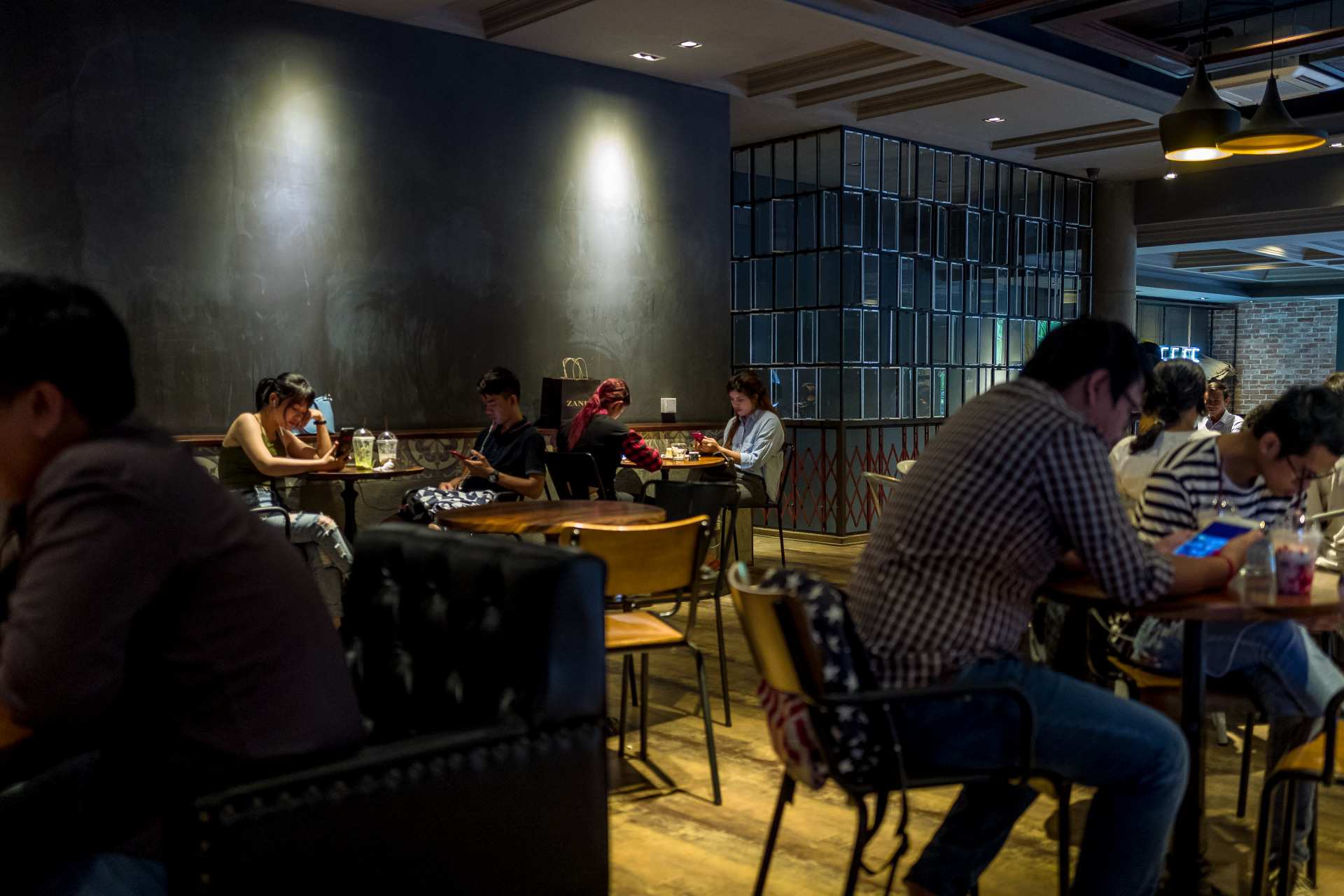 Young Cambodians sit inside a Brown Coffee Shop in Phnom Penh